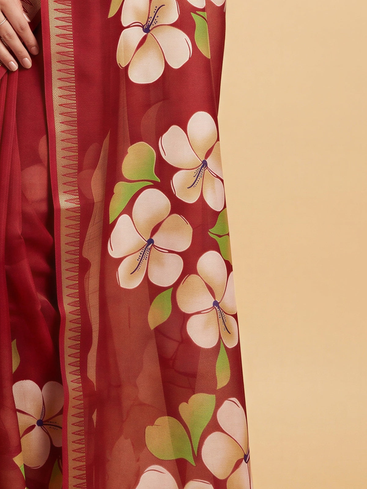 Pallu detail of maroon georgette saree showing all-over floral design and zari border