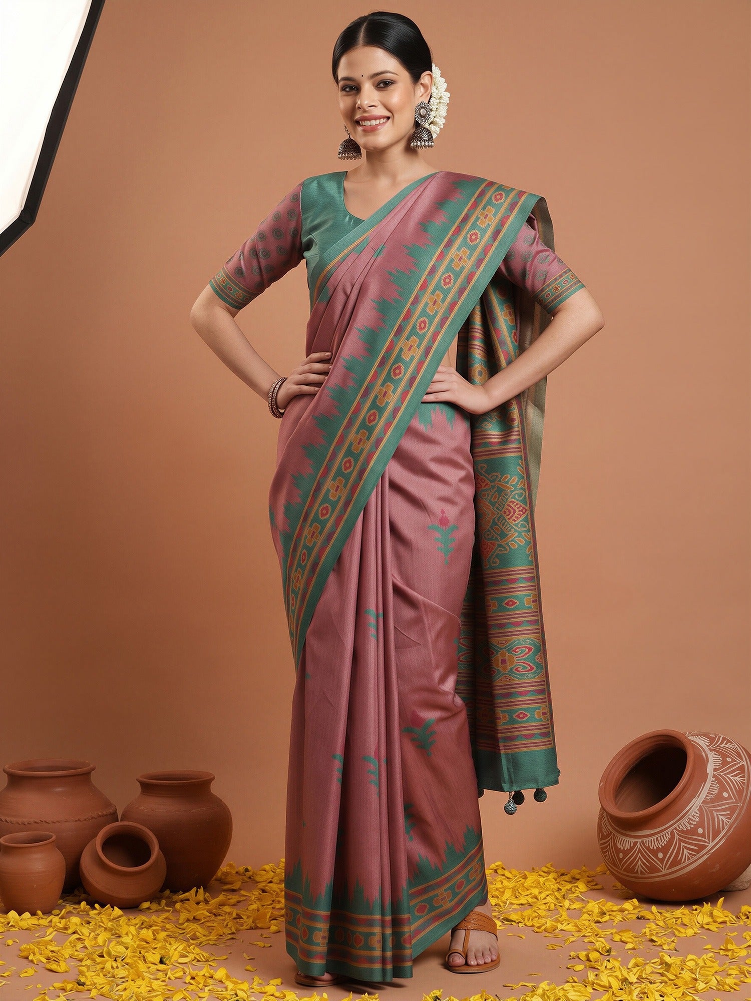 Woman wearing mauve silk blend saree with ikat resist-dyed pattern and teal green blouse