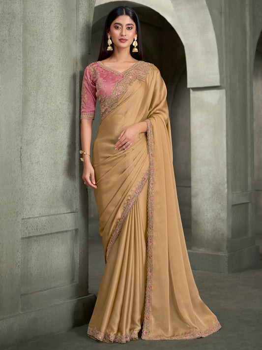 Woman wearing cream georgette saree with embroidered motif work and pink blouse