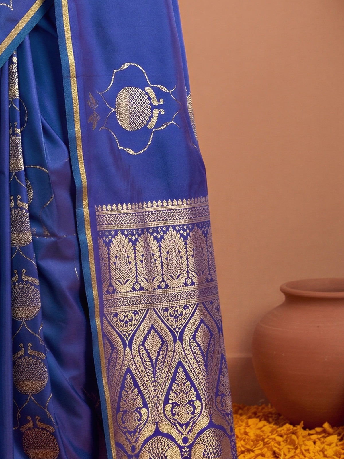 Pallu detail of blue satin saree showing zari butta (metallic motif) work and zari border