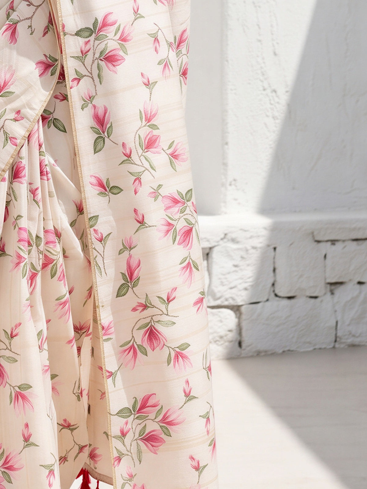 Pallu detail of off white cotton blend saree showing all-over floral design and embellished border