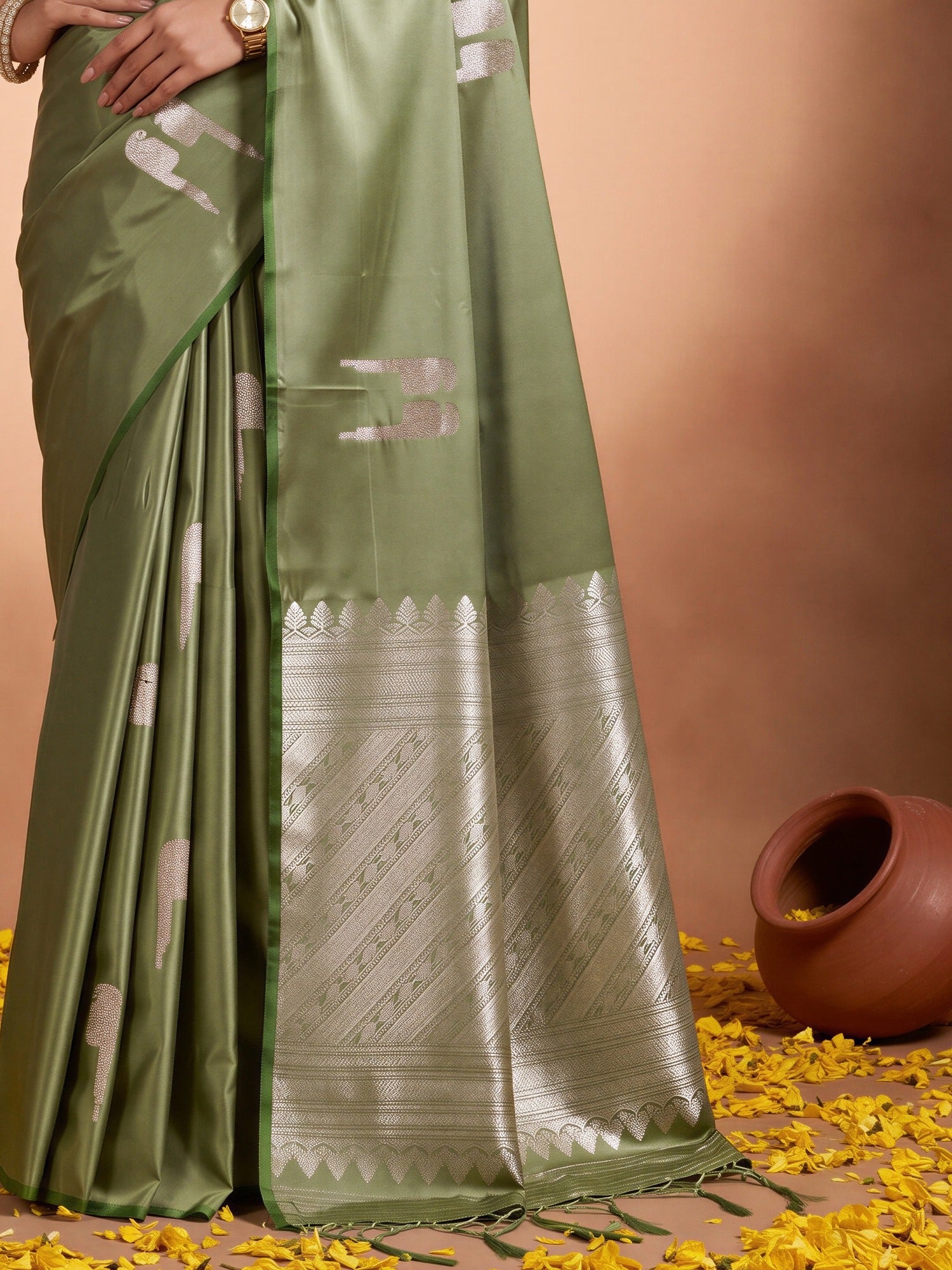 Pallu detail of green satin saree showing botanical floral and leaf design and zari border