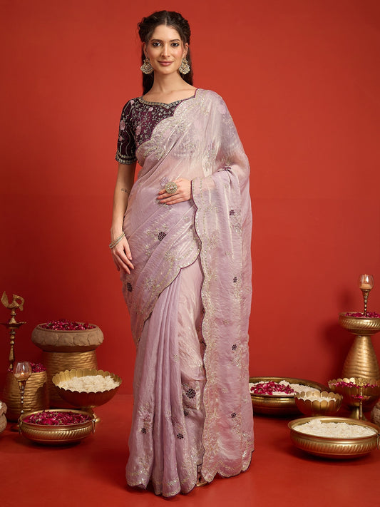 Woman wearing lavender satin silk saree with ornamented surface design and wine blouse