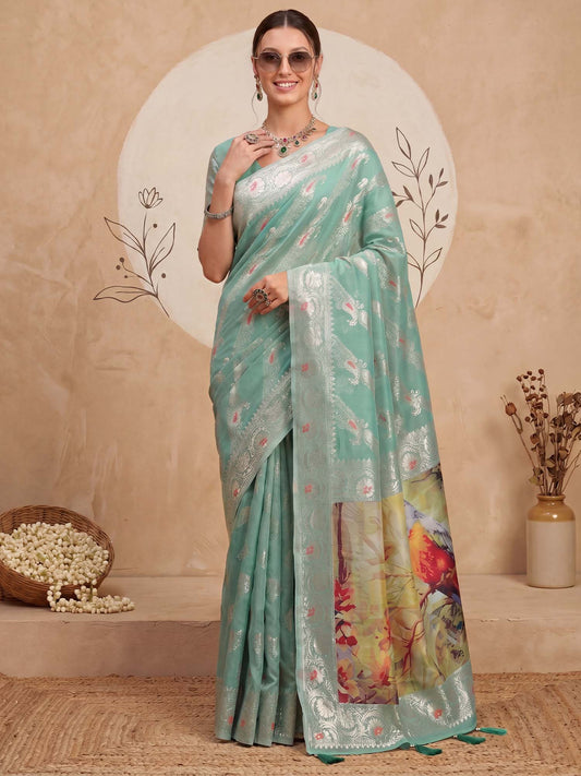 Woman wearing turquoise organza saree with traditional indian motif work and turquoise blouse