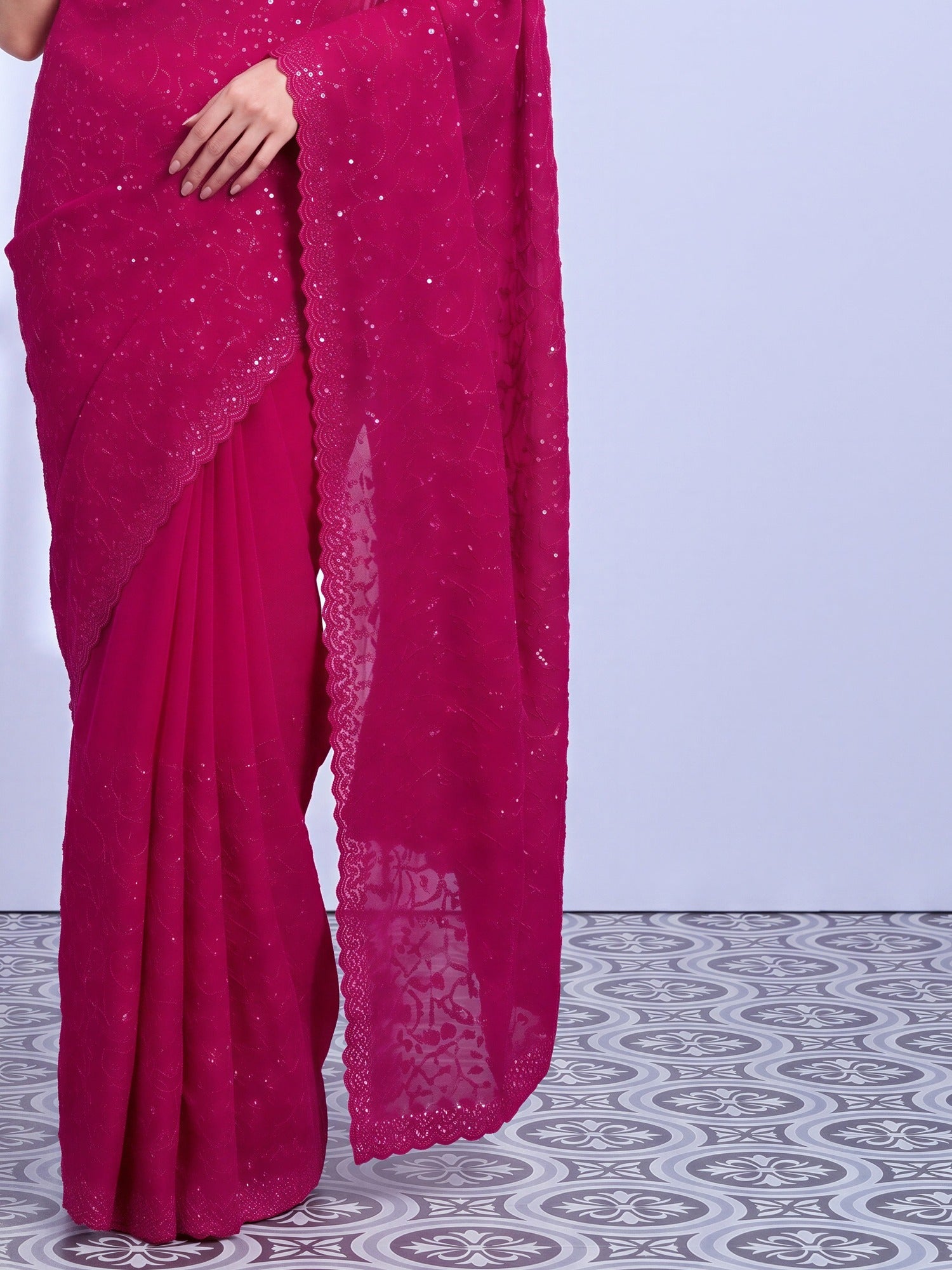 Pallu detail of pink tissue saree showing ornamented surface design and embellished border