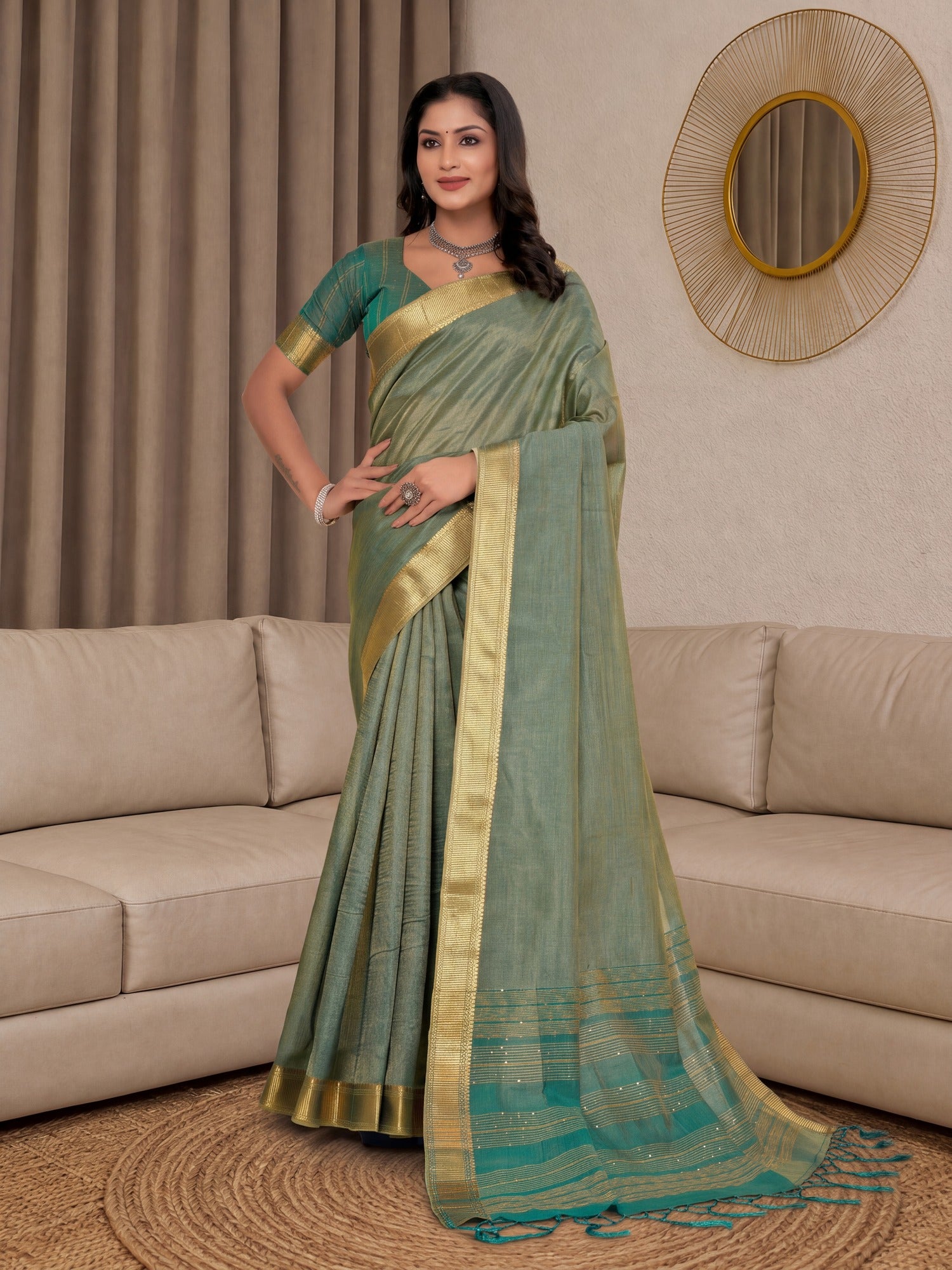 Woman wearing sea green cotton silk saree with clean solid-tone finish and teal green blouse