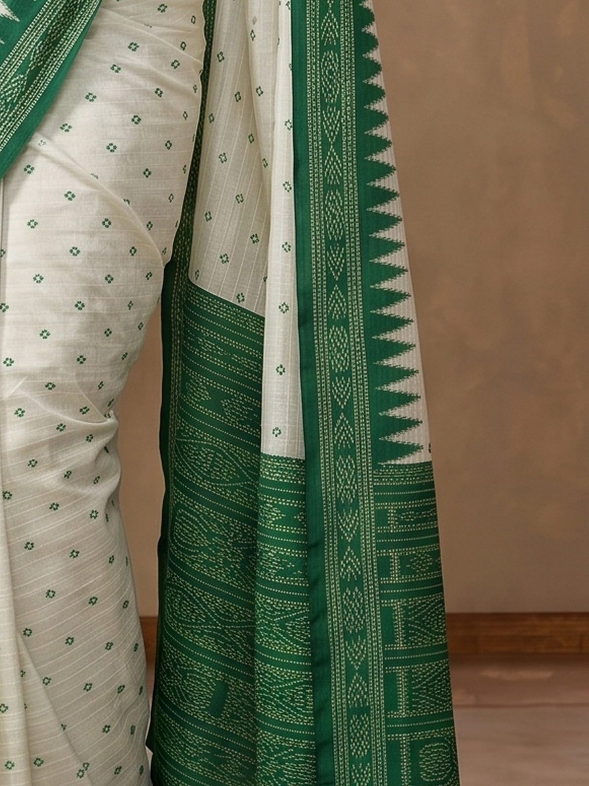 Pallu detail of off white tussar silk saree showing traditional indian motif work and printed border