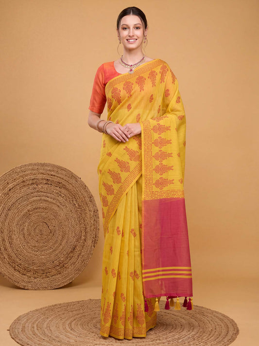 Woman wearing yellow linen saree with traditional indian motif work and orange blouse