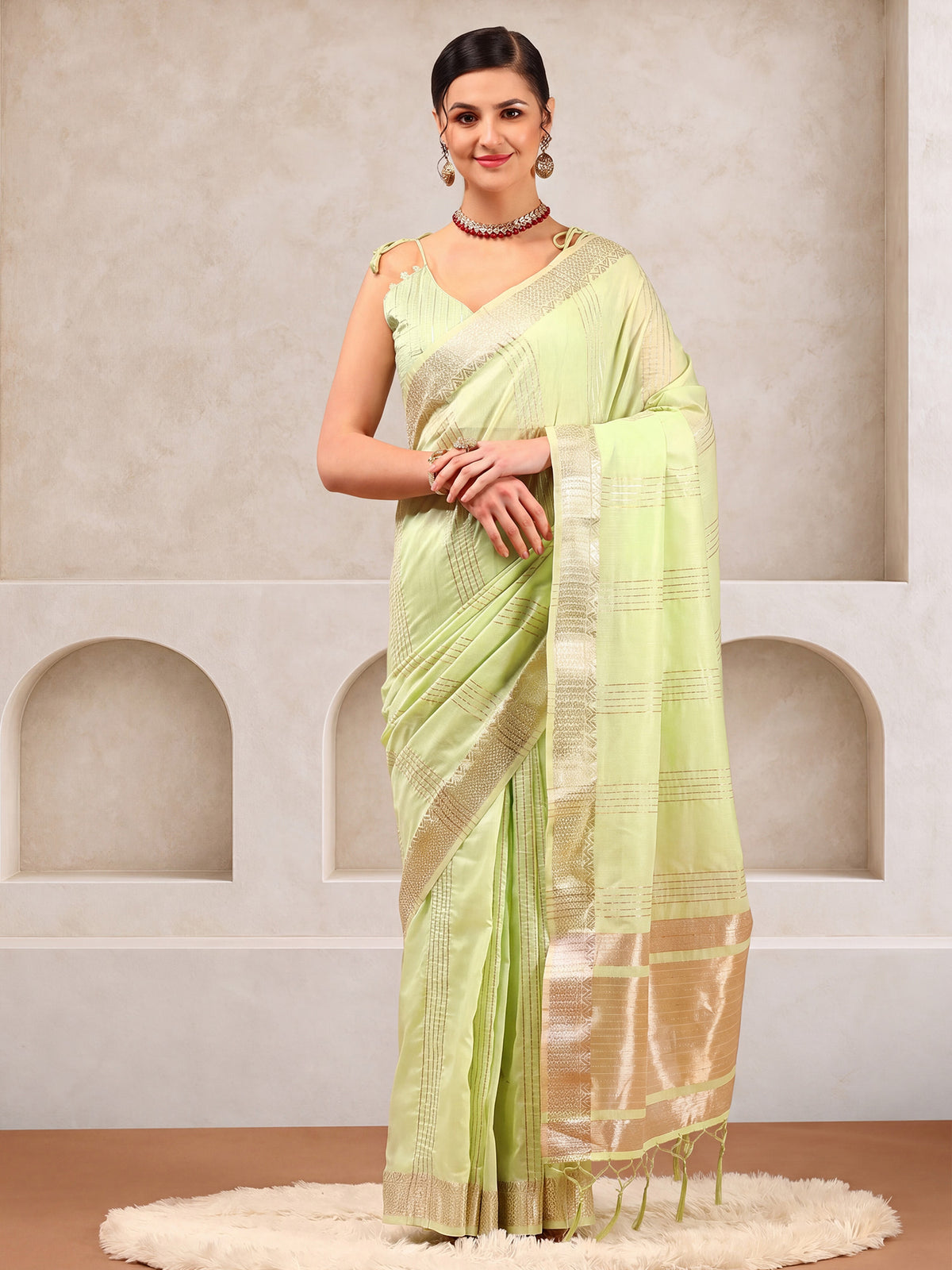 Woman wearing mint green linen saree with zari butta (metallic motif) work and mint green blouse