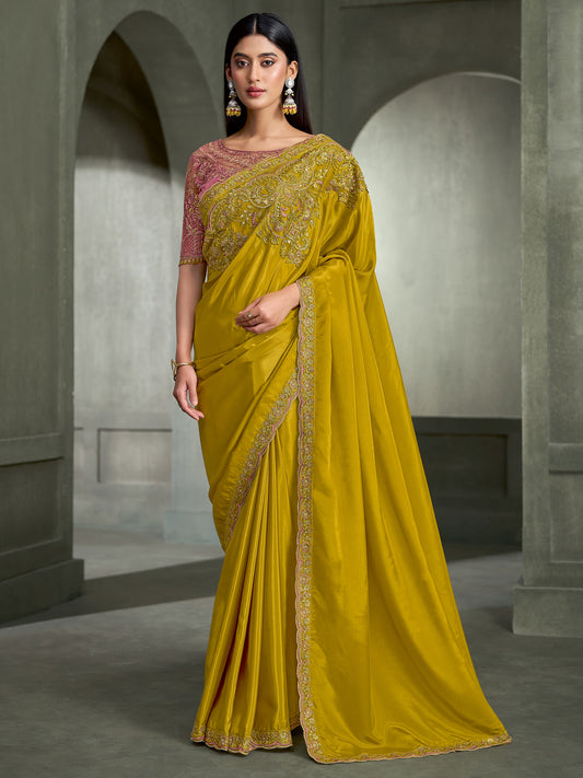 Woman wearing olive crepe saree with embroidered motif work and pink blouse