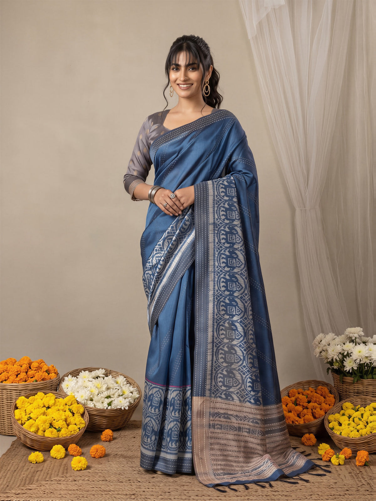 Woman wearing blue silk cotton saree with ikat resist-dyed pattern and grey blouse