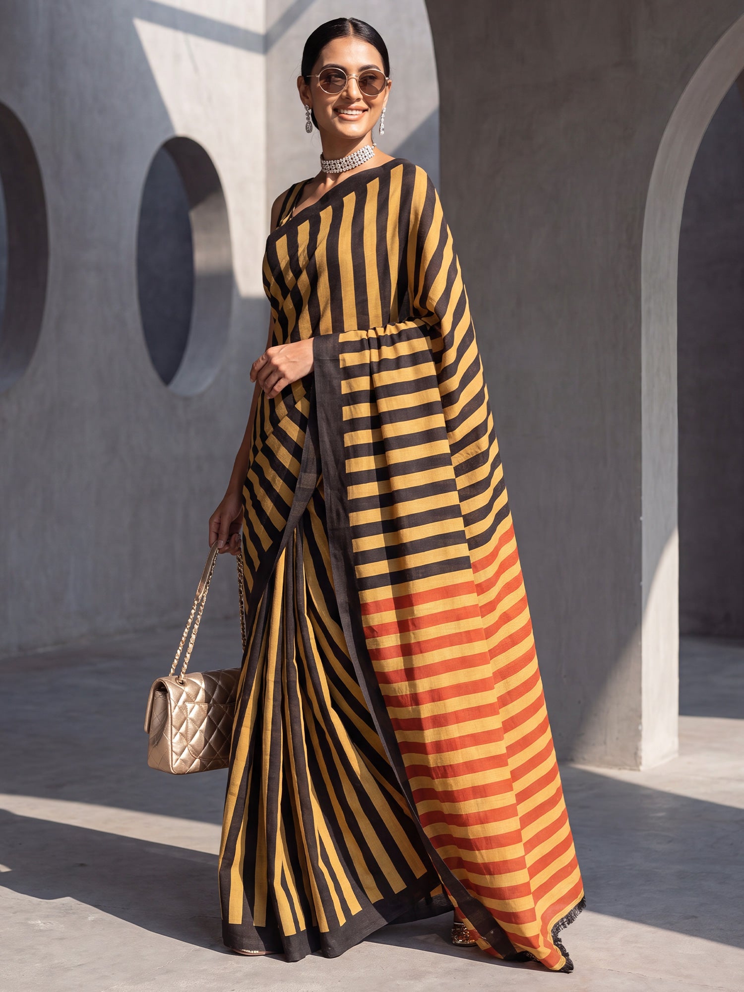 Woman wearing mustard cotton saree with striped pattern design and mustard blouse