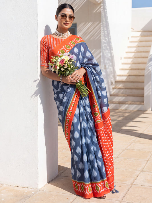 Woman wearing blue cotton saree with ikat resist-dyed pattern and orange blouse