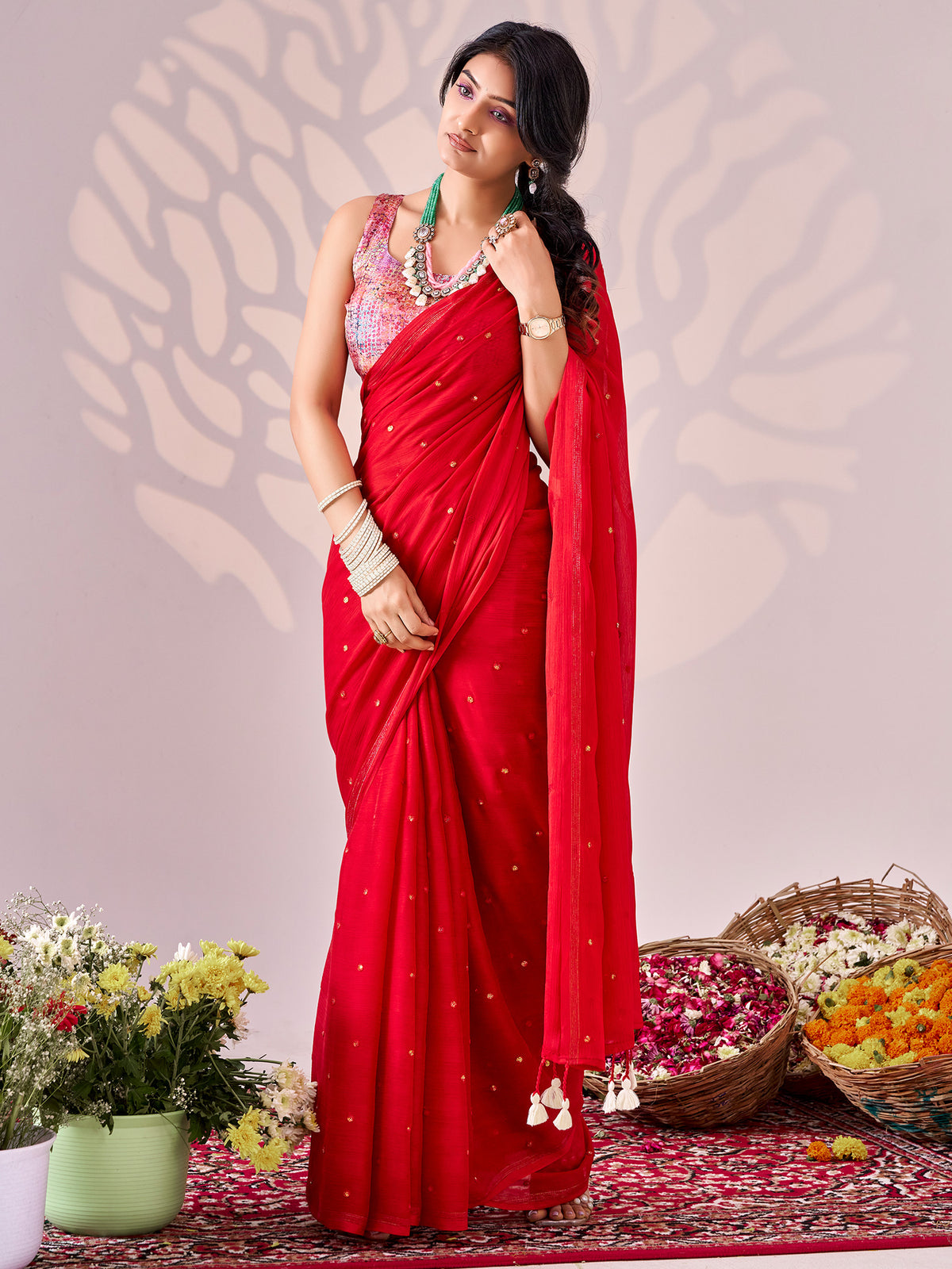 Woman wearing red chiffon saree with ornamented surface design and multicolored blouse