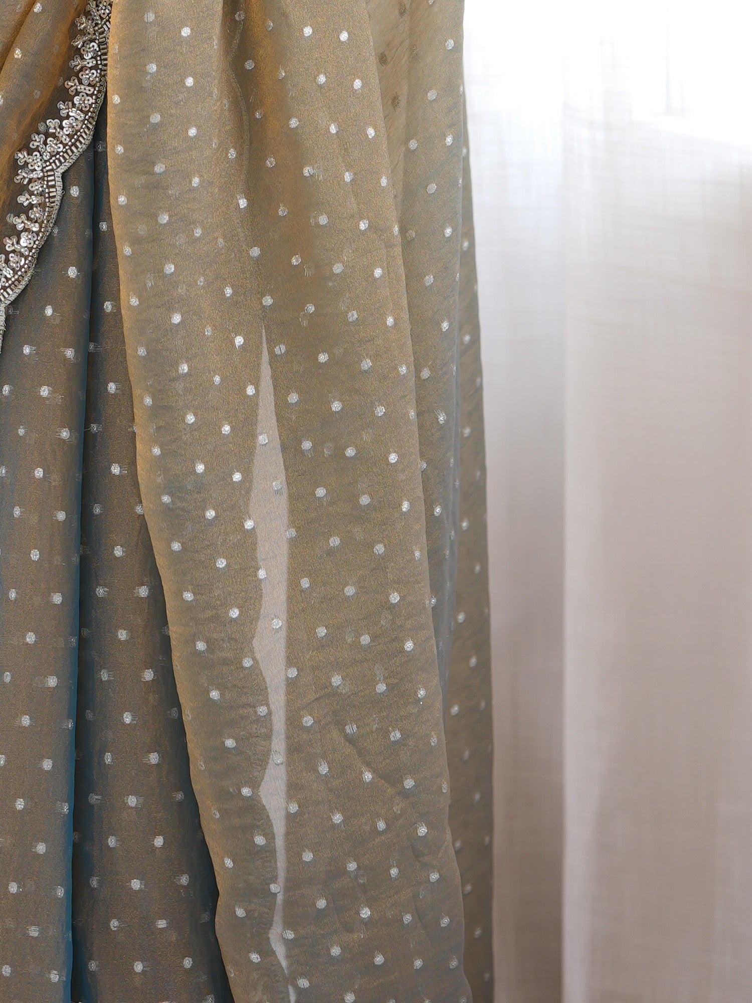 Pallu detail of metallic silk blend saree showing ornamented surface design and scallop border