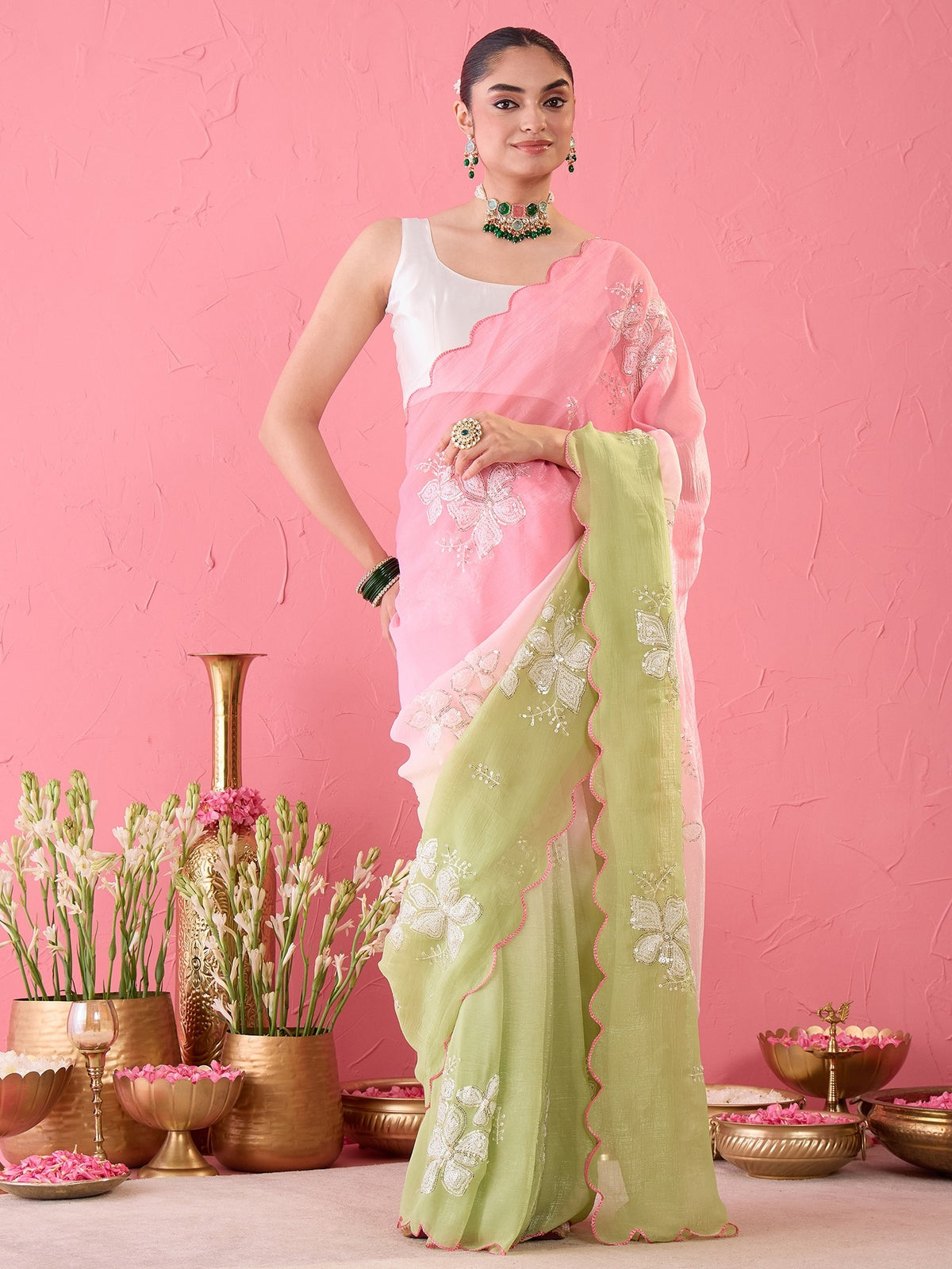 Woman wearing pink chiffon ready to wear saree with ornamented surface design and white blouse