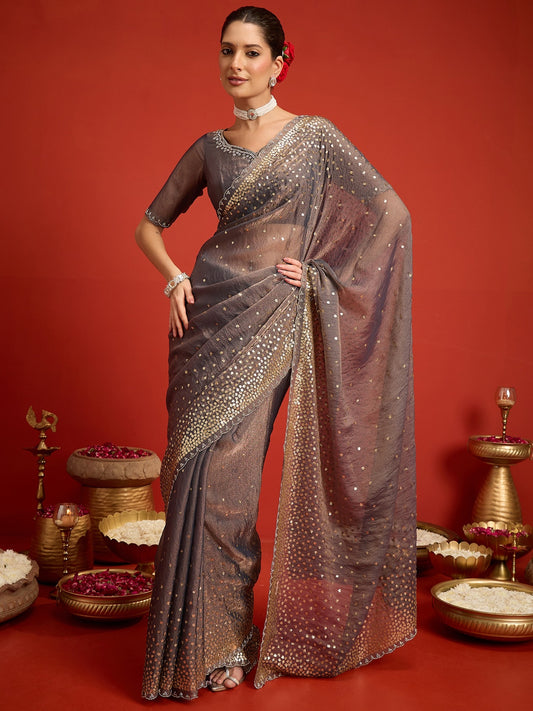 Woman wearing charcoal grey organza saree with ornamented surface design and charcoal grey blouse