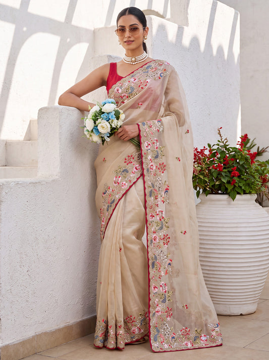 Woman wearing beige organza saree with embroidered motif work and red blouse