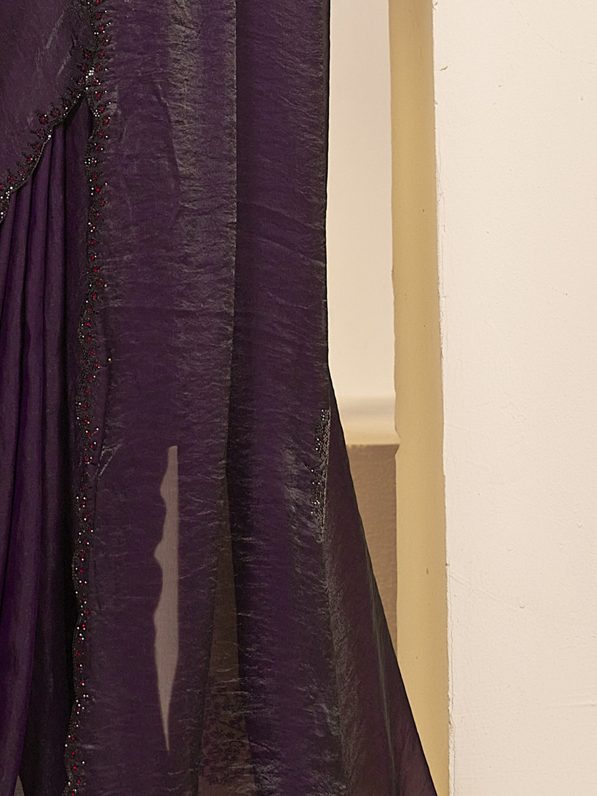 Pallu detail of wine satin silk saree showing ornamented surface design and embellished border