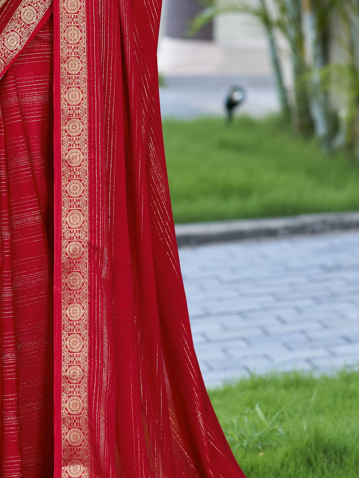 Pallu detail of red jacquard saree showing striped pattern design and zari border