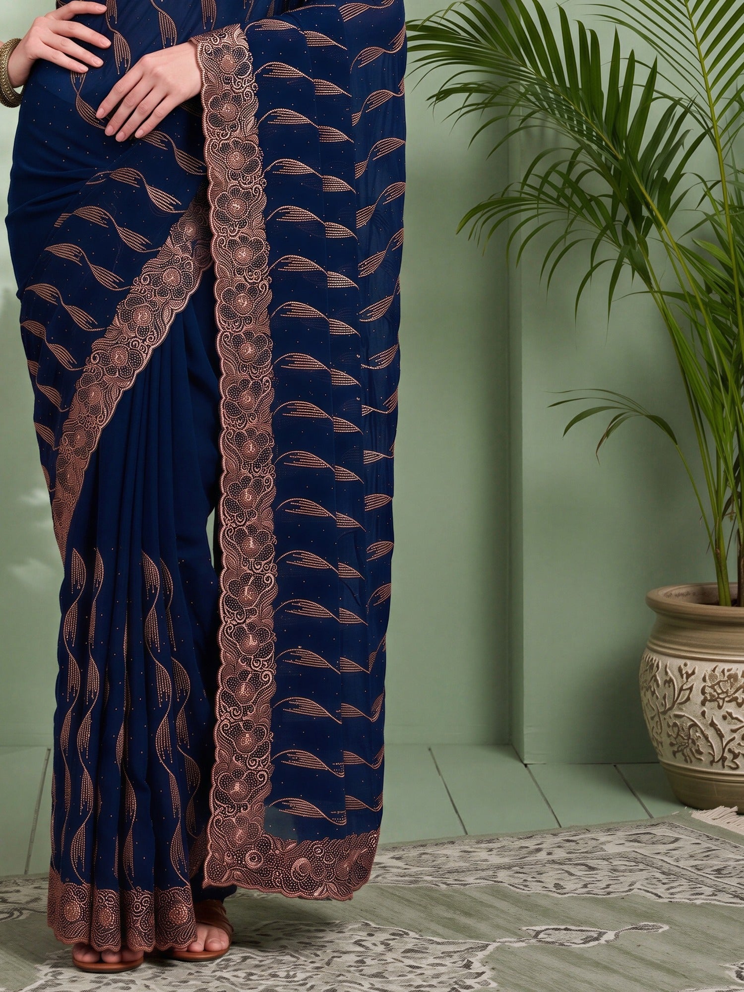 Pallu detail of teal blue pure georgette saree showing geometric pattern design and embroidered border