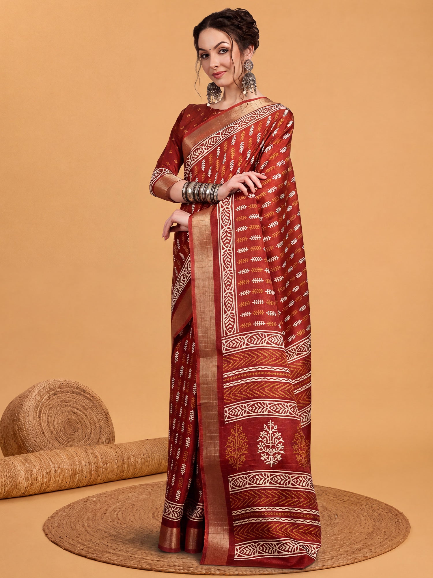 Woman wearing rust silk blend saree with traditional indian motif work and rust blouse