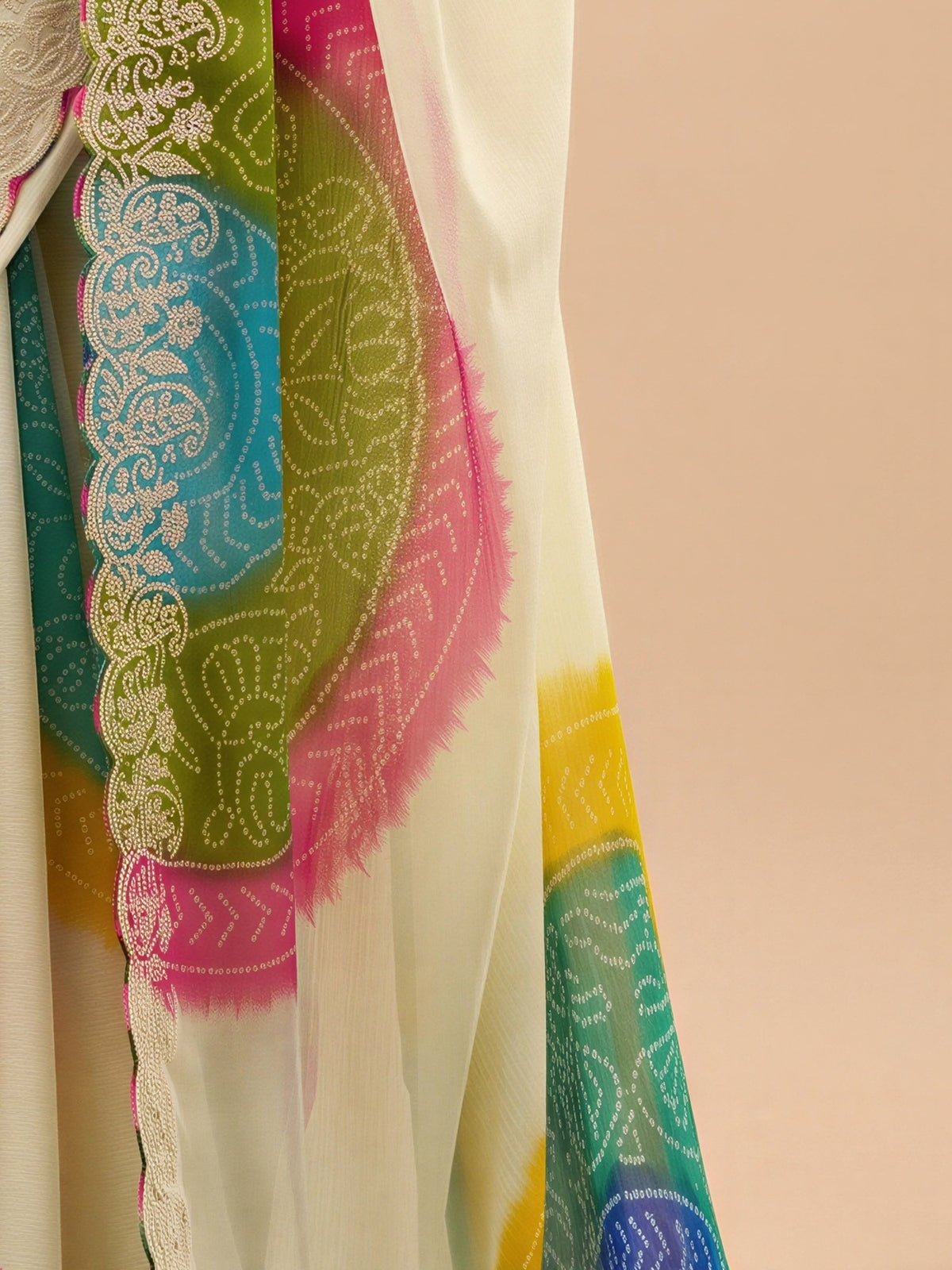 Pallu detail of cream chiffon saree showing bandhani tie-dye dot work and scallop border