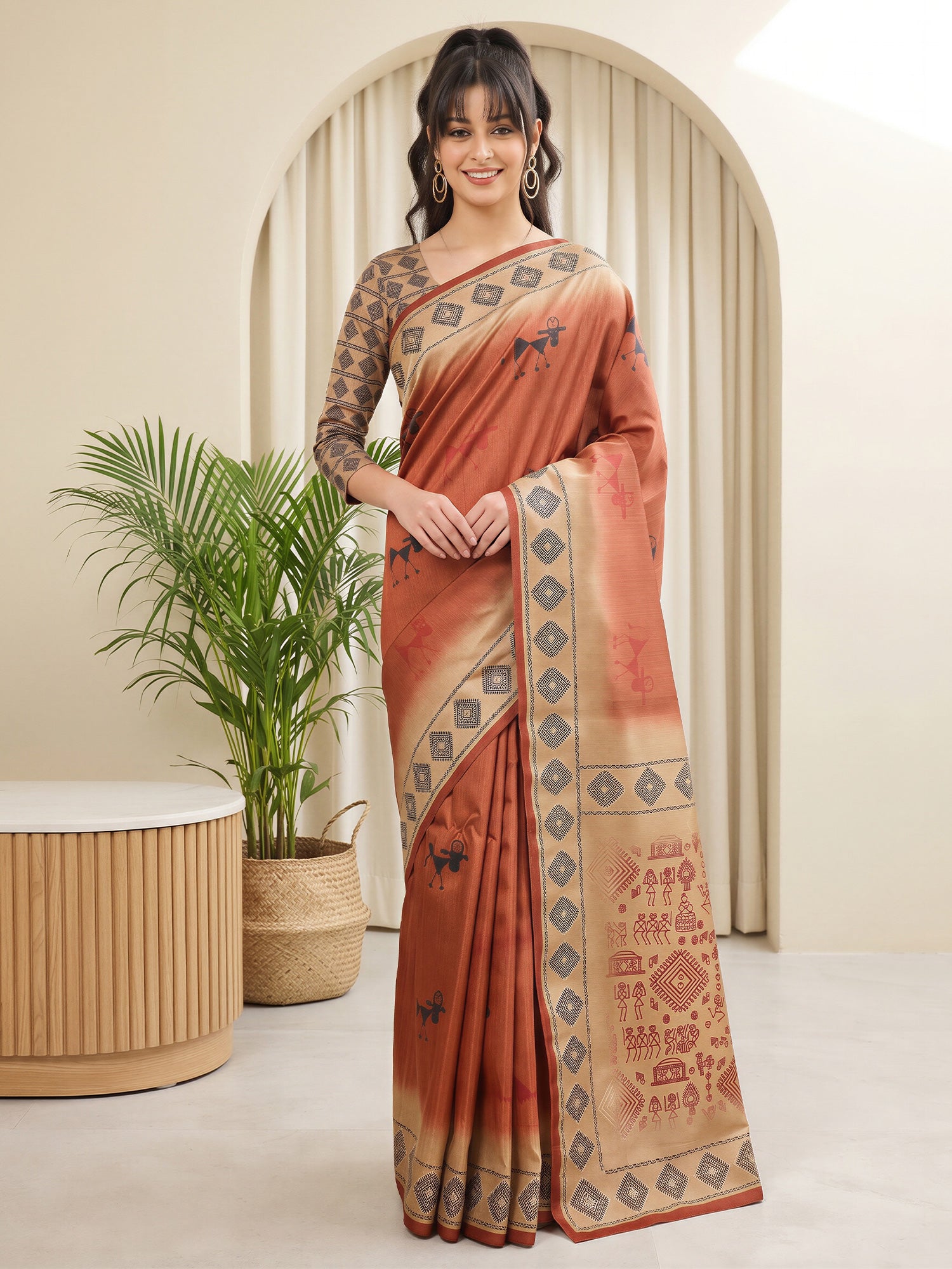 Woman wearing rust silk blend saree with tribal folk-art motifs and beige blouse