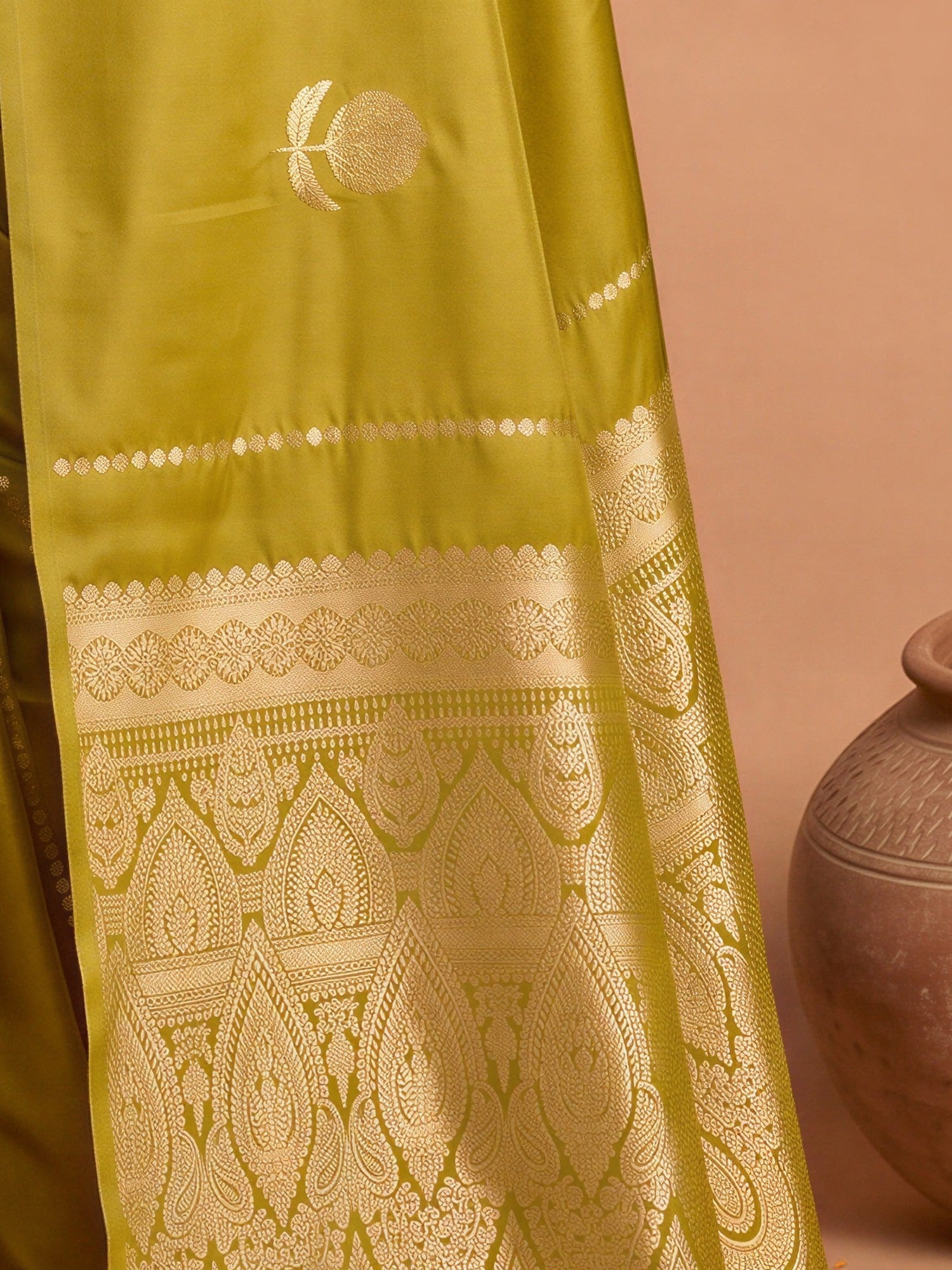 Pallu detail of mustard satin silk saree showing traditional indian motif work and no border border