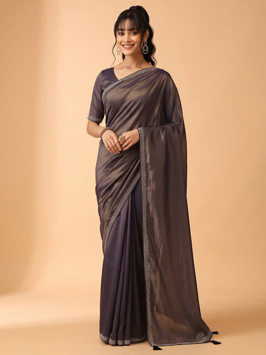 Woman wearing navy blue satin silk saree with ornamented surface design and navy blue blouse