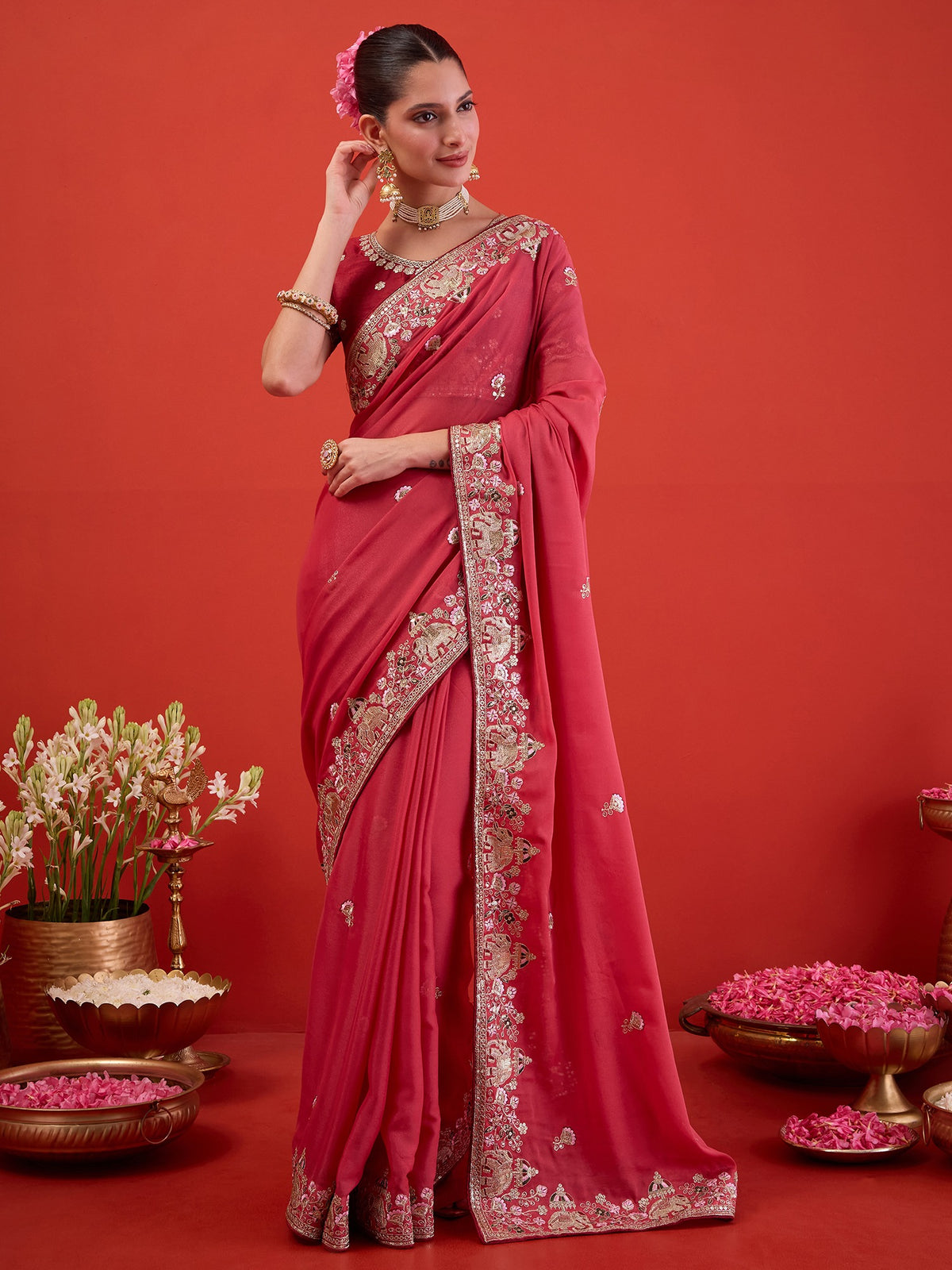 Woman wearing pink georgette saree with ornamented surface design and maroon blouse
