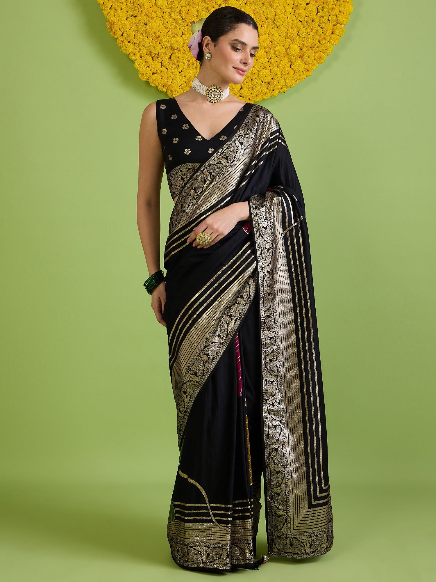 Woman wearing black silk blend saree with zari butta (metallic motif) work and black blouse