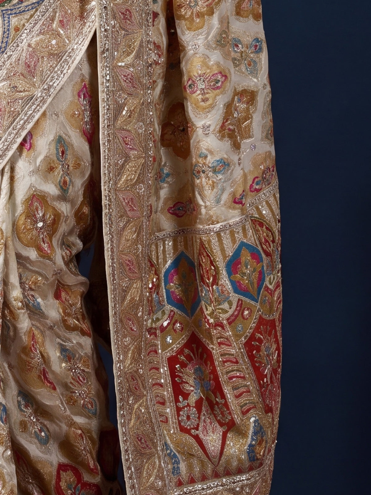 Pallu detail of white silk blend saree showing traditional indian motif work and embellished border