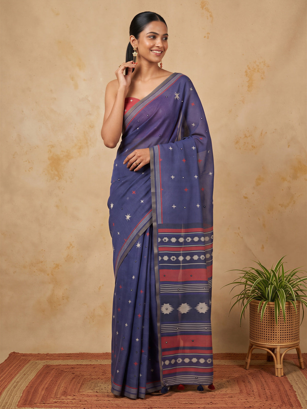 Woman wearing navy blue linen blend saree with geometric pattern design and orange blouse