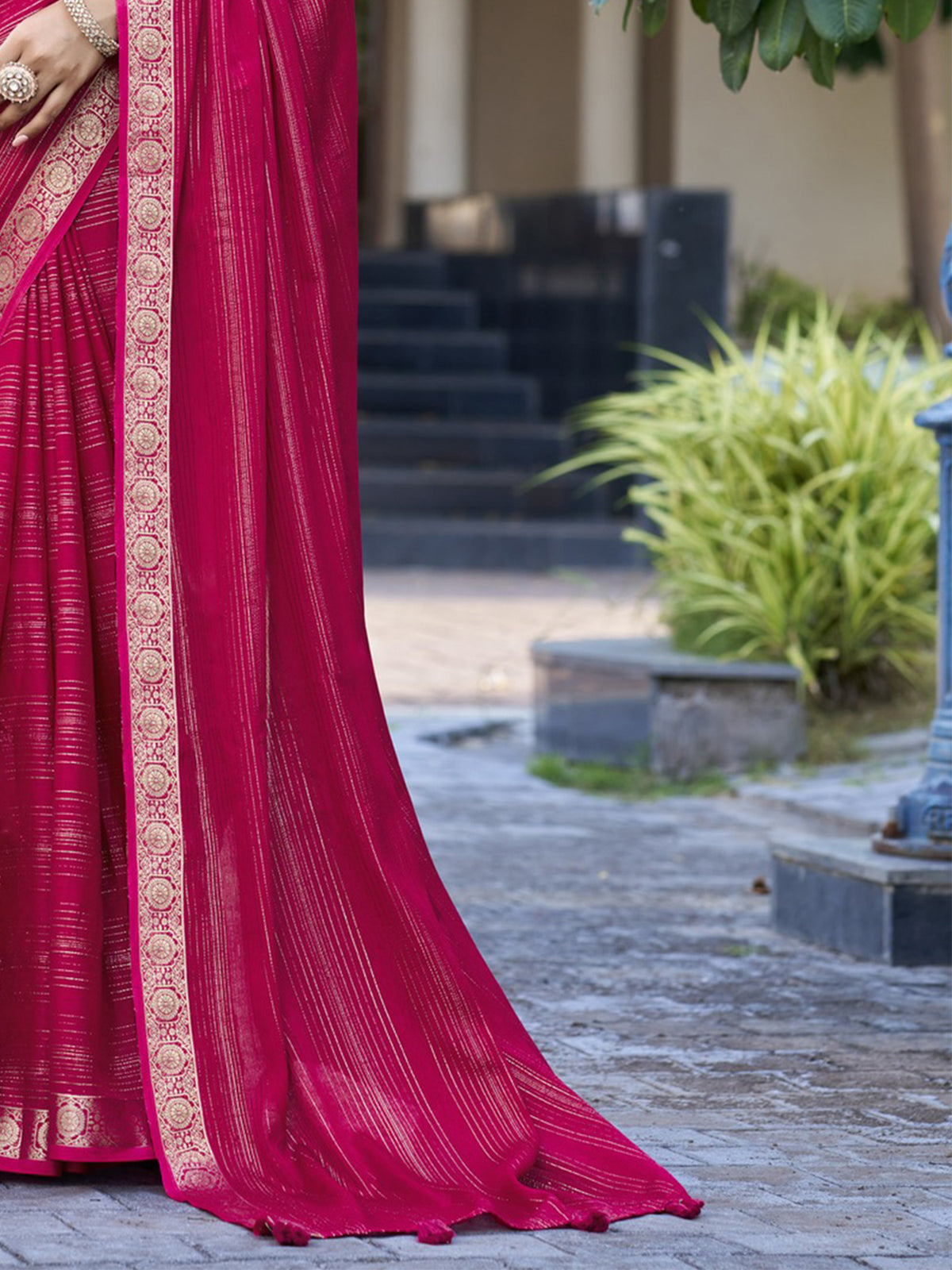 Pallu detail of pink jacquard saree showing striped pattern design and zari border