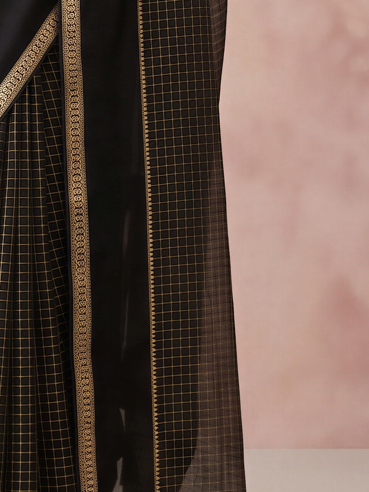 Pallu detail of black viscose saree showing checked pattern design and zari border