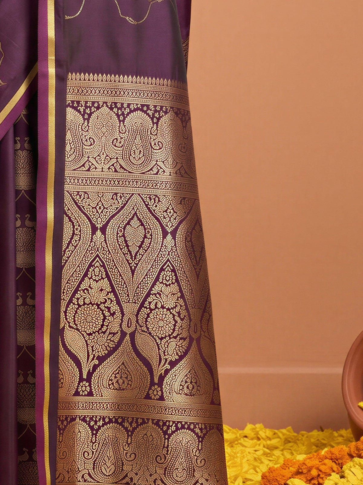 Pallu detail of purple satin saree showing zari butta (metallic motif) work and zari border