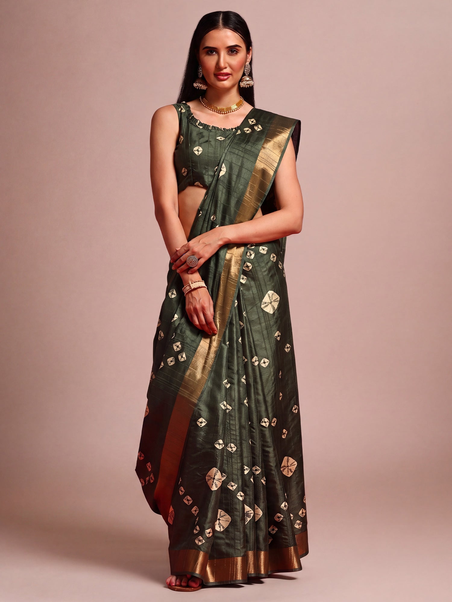 Woman wearing dark green silk blend saree with traditional indian motif work and dark green blouse