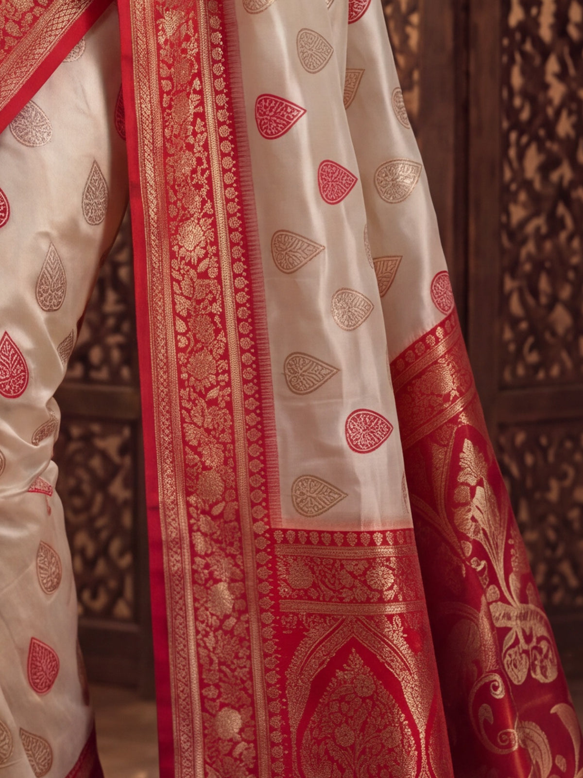 Pallu detail of white banarasi silk saree showing zari butta (metallic motif) work and zari border