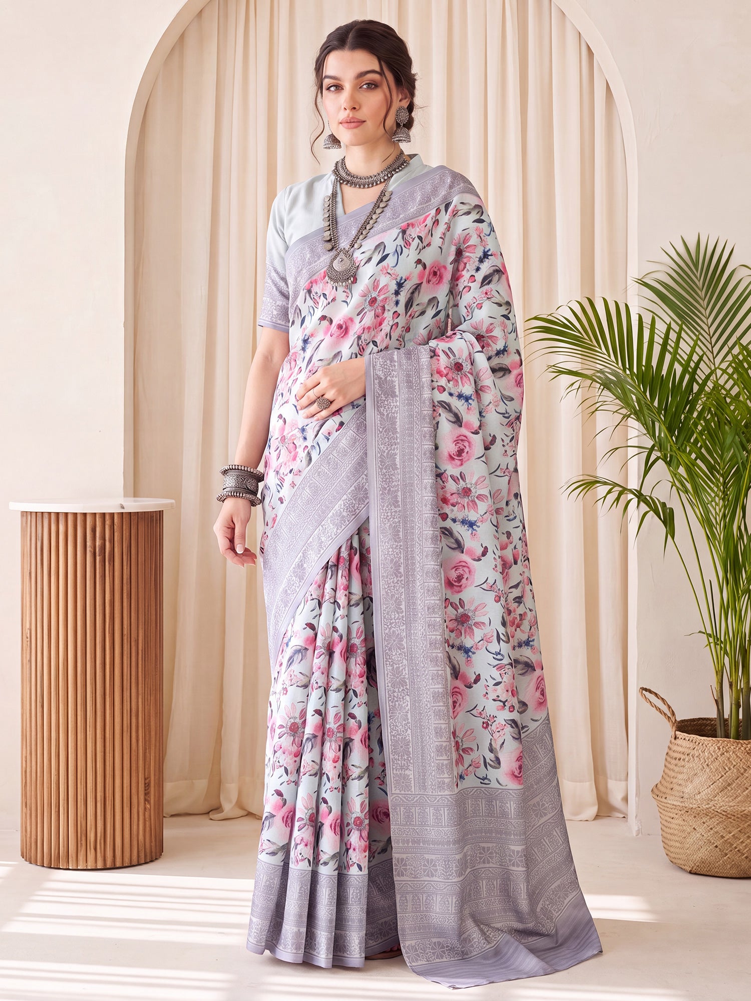 Woman wearing light blue silk blend saree with botanical floral and leaf design and light blue blouse