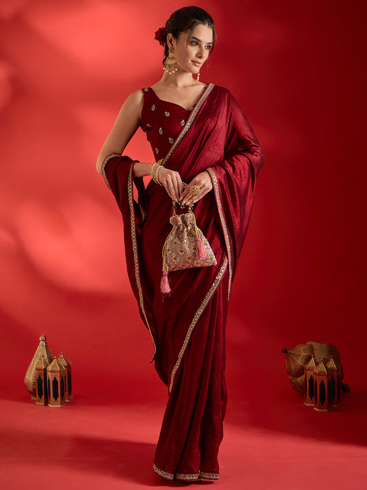Woman wearing maroon vichitra silk saree with clean solid-tone finish and maroon blouse