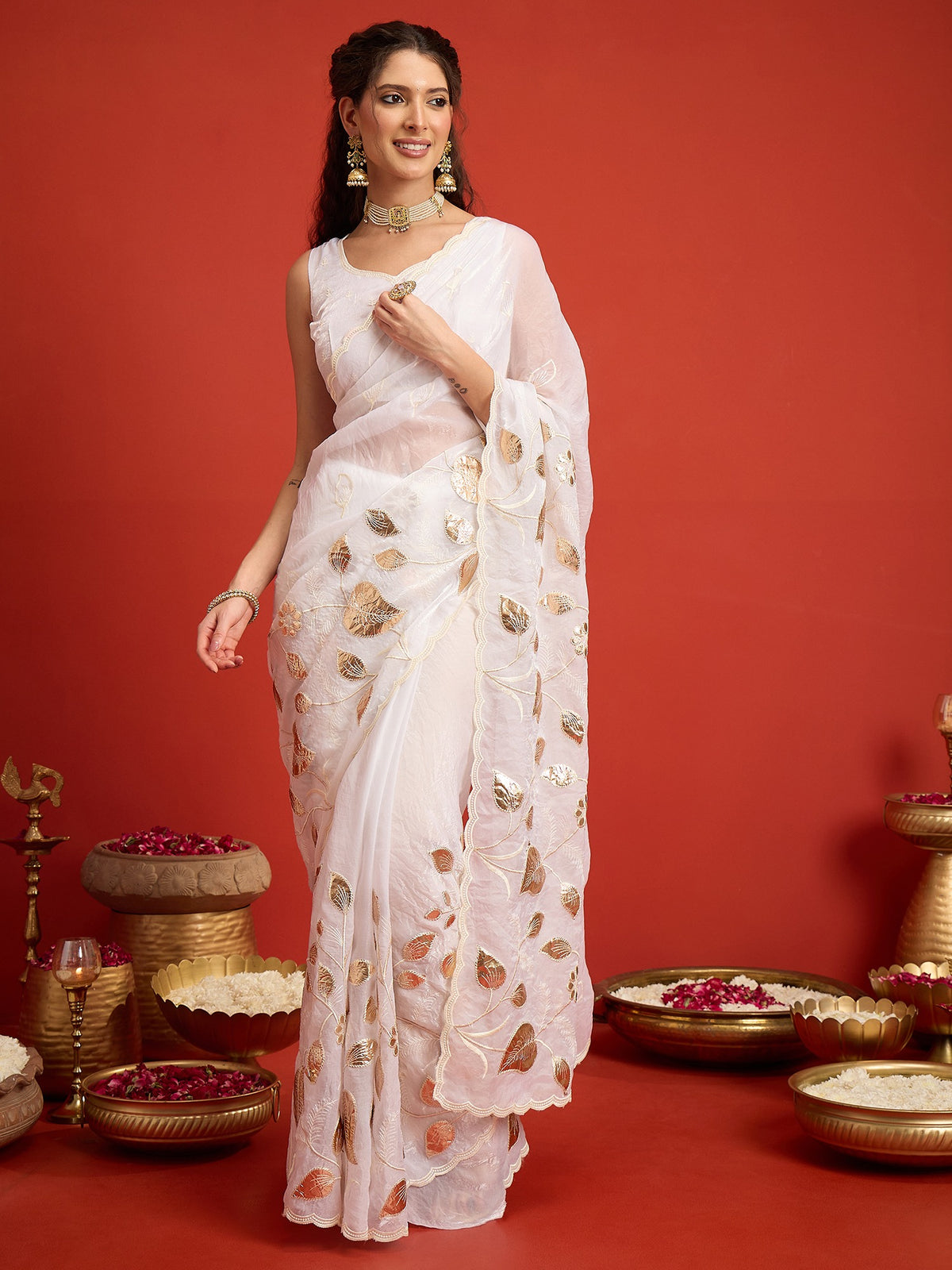 Woman wearing white satin silk saree with ornamented surface design and white blouse