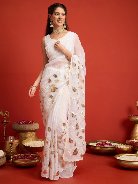 Woman wearing white satin silk saree with ornamented surface design and white blouse