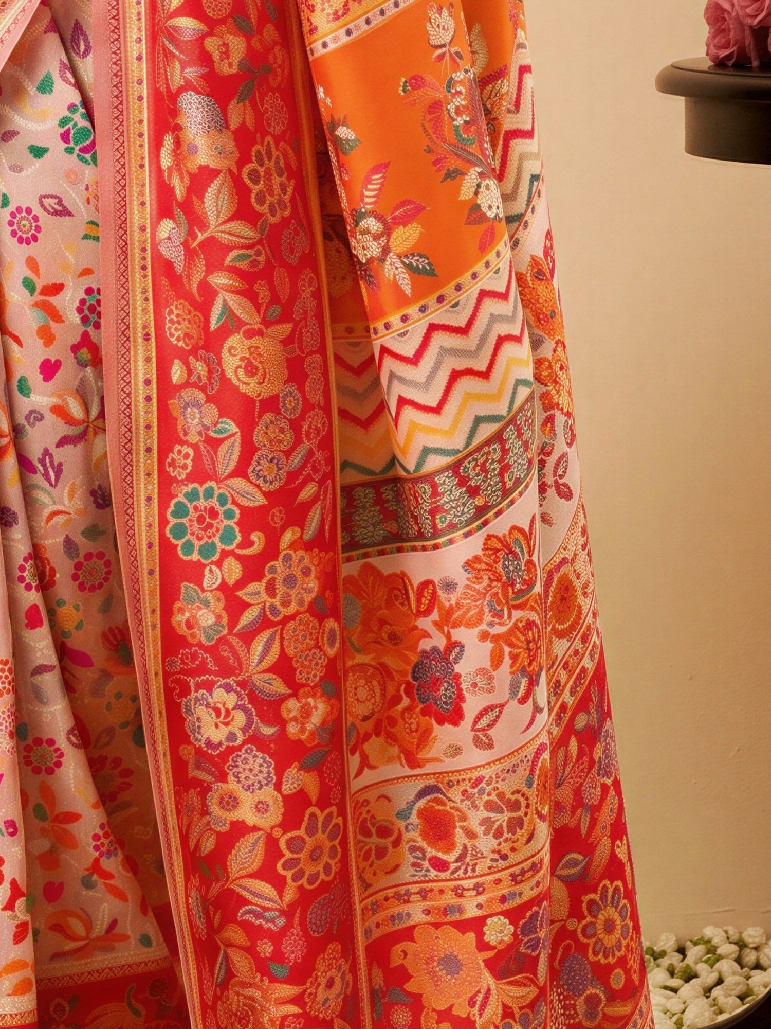Pallu detail of pink cotton silk saree showing all-over floral design and woven design border