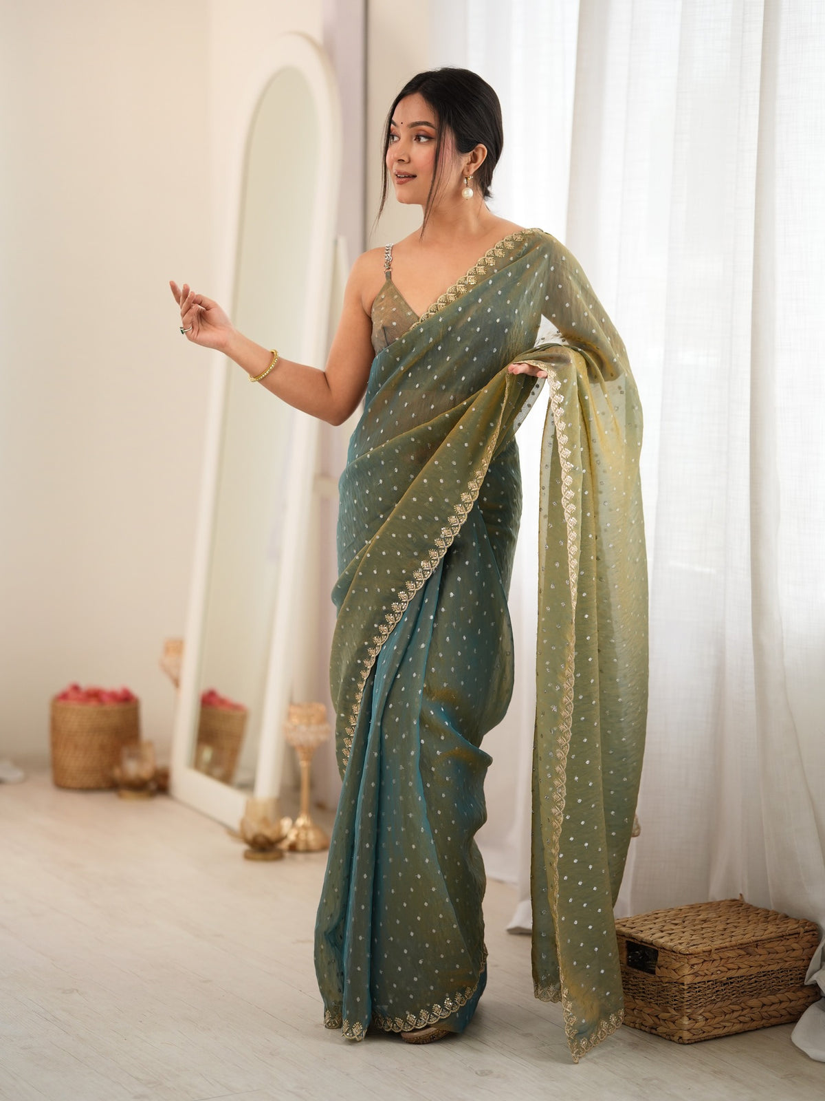 Woman wearing olive georgette saree with zari butta (metallic motif) work and olive blouse