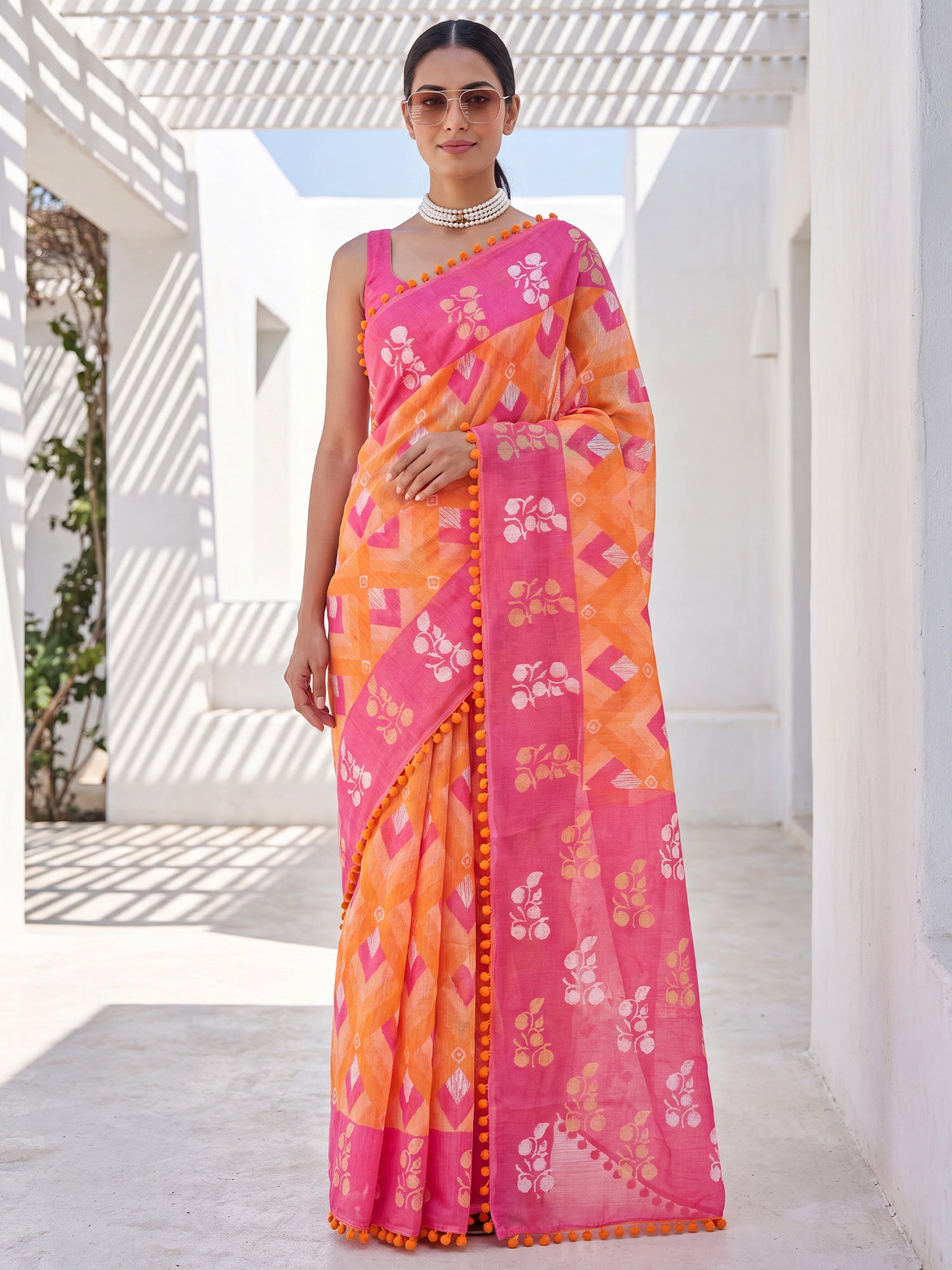 Woman wearing orange cotton saree with chevron zigzag pattern and pink blouse