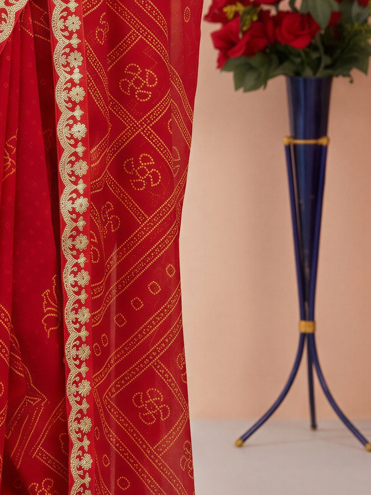 Pallu detail of orange georgette saree showing bandhani tie-dye dot work and embellished border