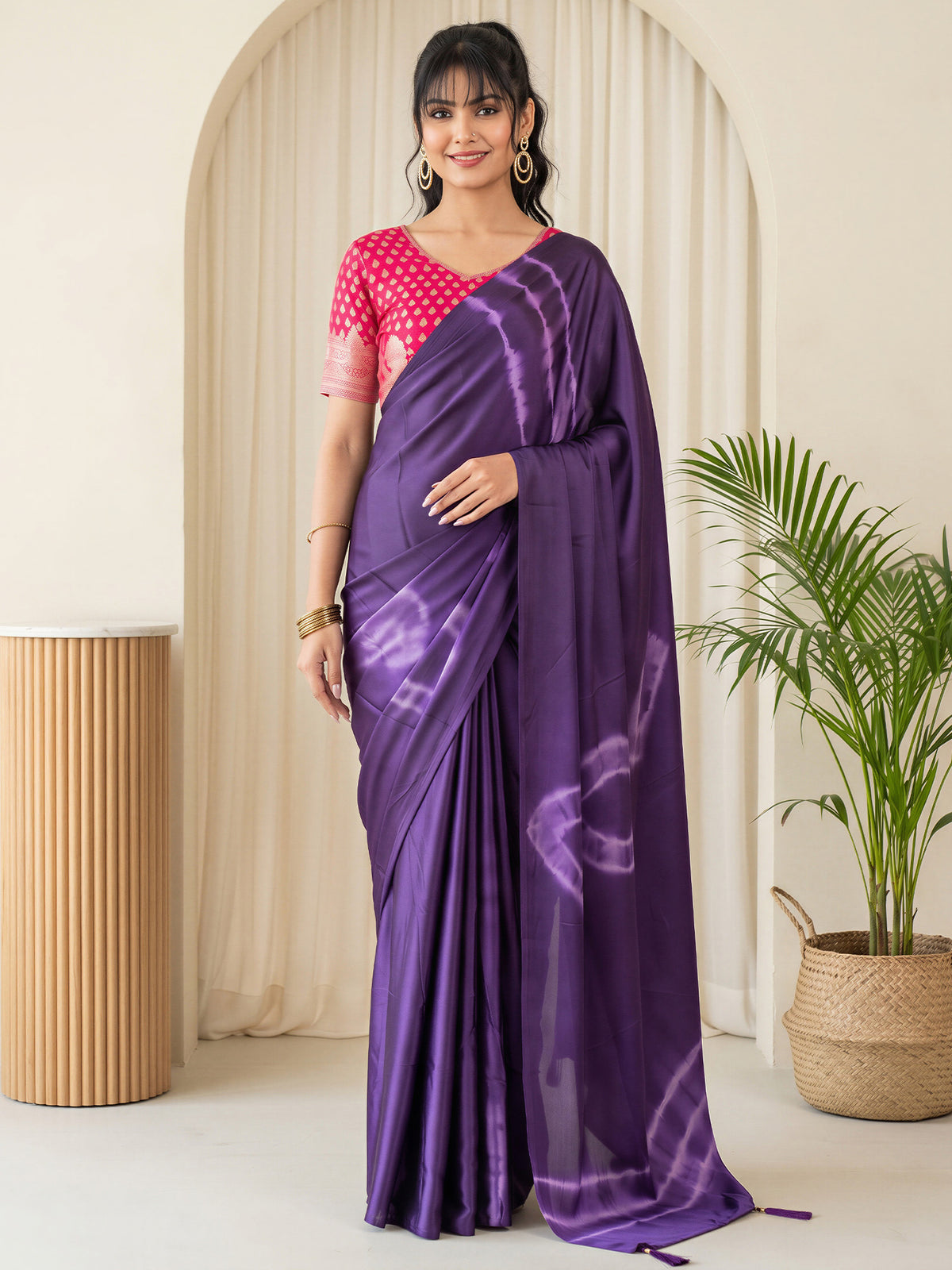 Woman wearing purple satin silk saree with tie-and-dye resist pattern and pink blouse