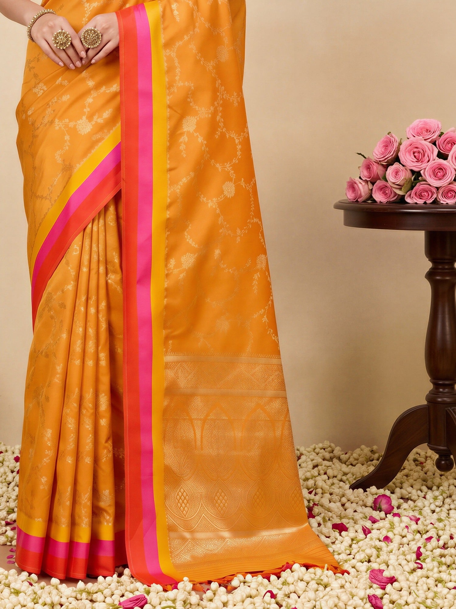 Pallu detail of orange pure silk saree showing traditional indian motif work and zari border