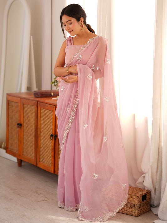 Woman wearing pink georgette saree with ornamented surface design and pink blouse